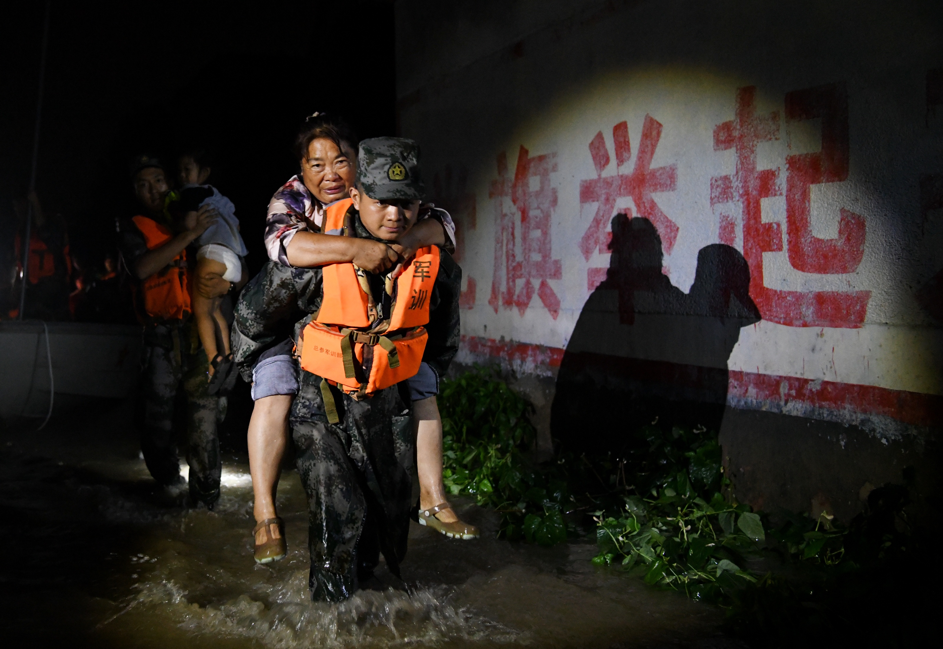 2021 年 7 月，官兵們轉(zhuǎn)移被洪水圍困的群眾。 本報(bào)記者 聶冬晗 本報(bào)通訊員 季鵬.jpeg